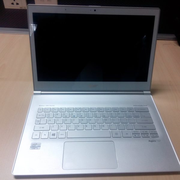 لابتوب فضي مفتوح على مكتب خشبي فاتح